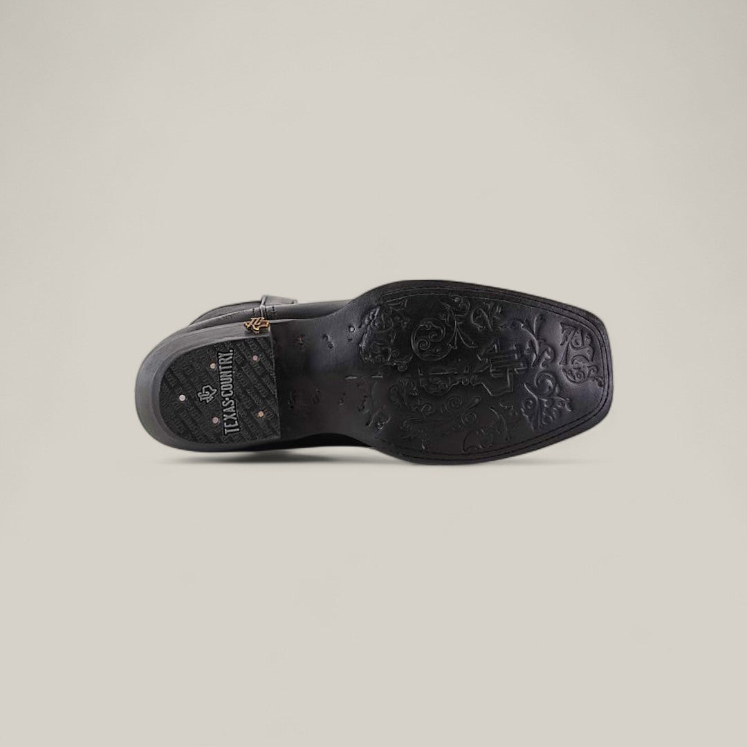 The image displays the sole of the Josie Full Black - Short Shaft - Narrow Square Toe, featuring intricate floral patterns and LUX SEMNLUX embossed near the heel, set against a plain light background for a chic, sophisticated look.
