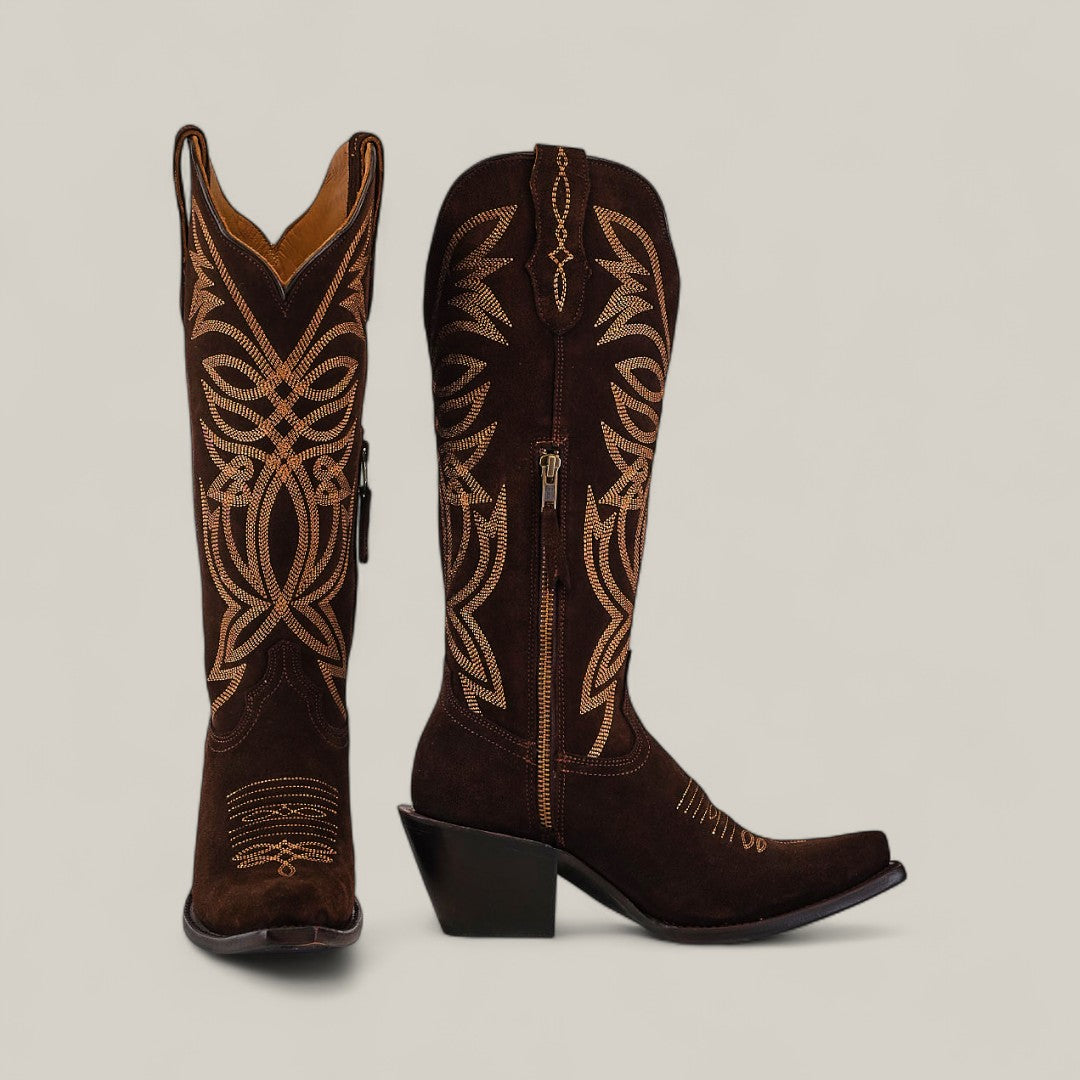 The Kellie Suede Brownie Leather Sole boots feature a tall shaft, snip toe, tan decorative stitching, side zippers, and angled heels. Displayed against a plain background; one stands upright while the other shows off its sleek leather sole.