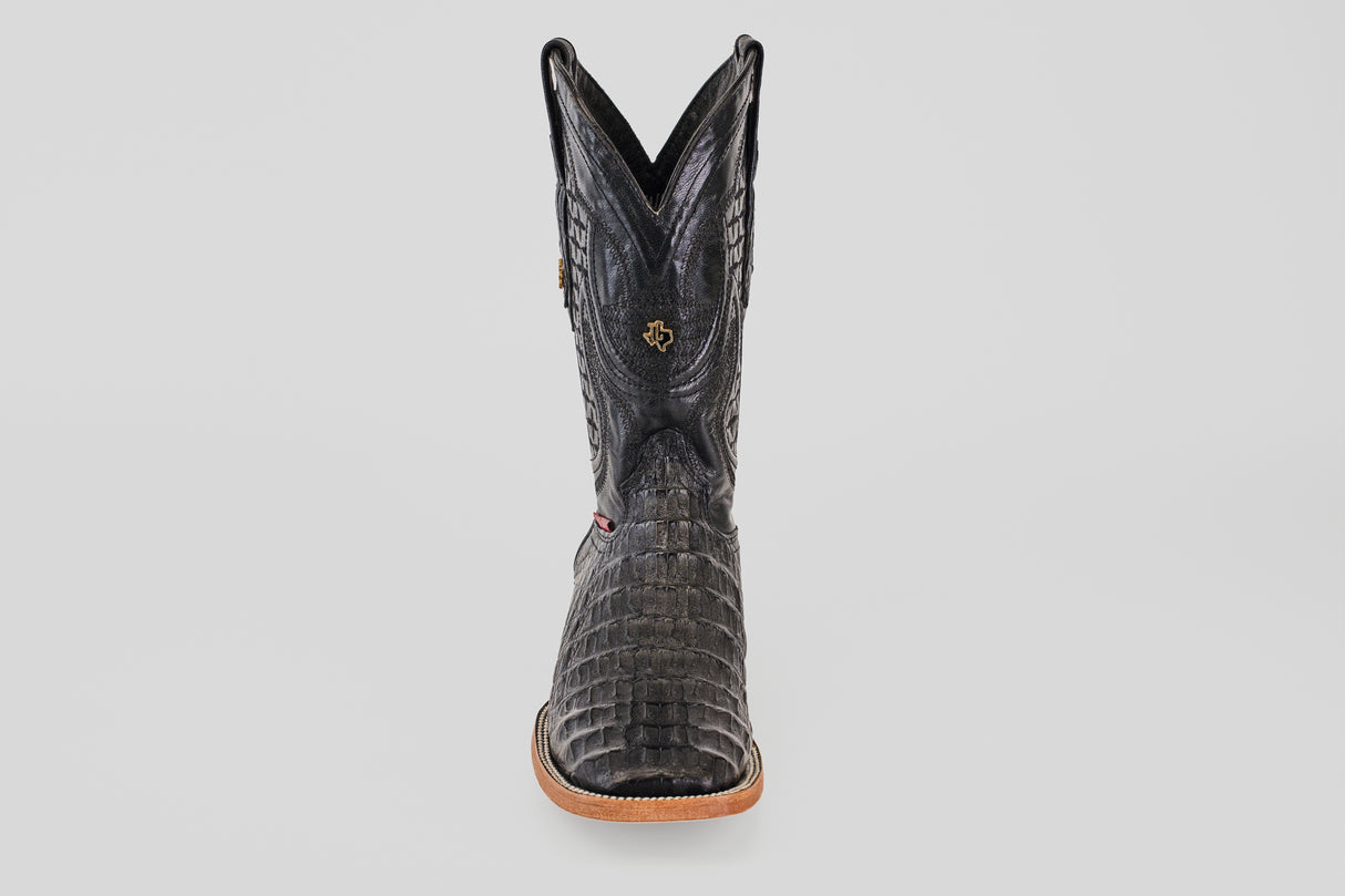 A single Exotic Caiman Horn Back boot in black with a square toe, tan sole, and decorative stitching, photographed from the front against a plain white background.