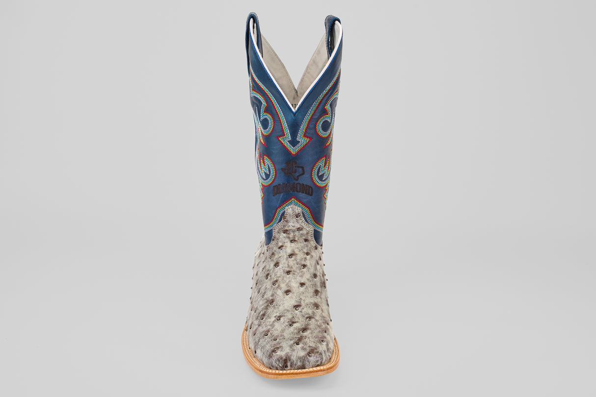 A single Russell - Rustic Gray - Square Toe Western boot with a light brown ostrich leather foot, blue shaft, decorative stitching, and tan sole is shown facing forward against a plain light background.