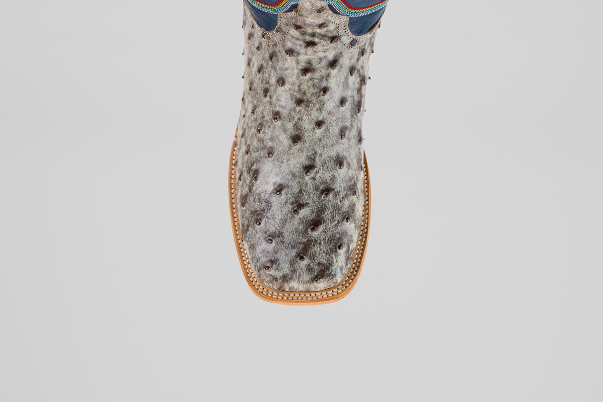 A top-down view of the Russell - Rustic Gray - Square Toe boot, featuring a textured, spotted gray surface, square toe, and tan stitching.