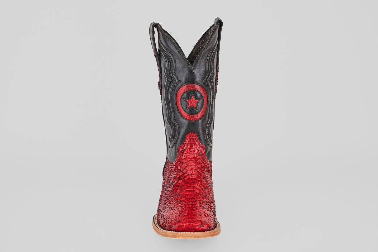 The Tanner - Ruby - Square Toe boot features a red textured lower half, black upper, and a Python Rojo star emblem on the front shaft, displayed upright against a plain light gray background.