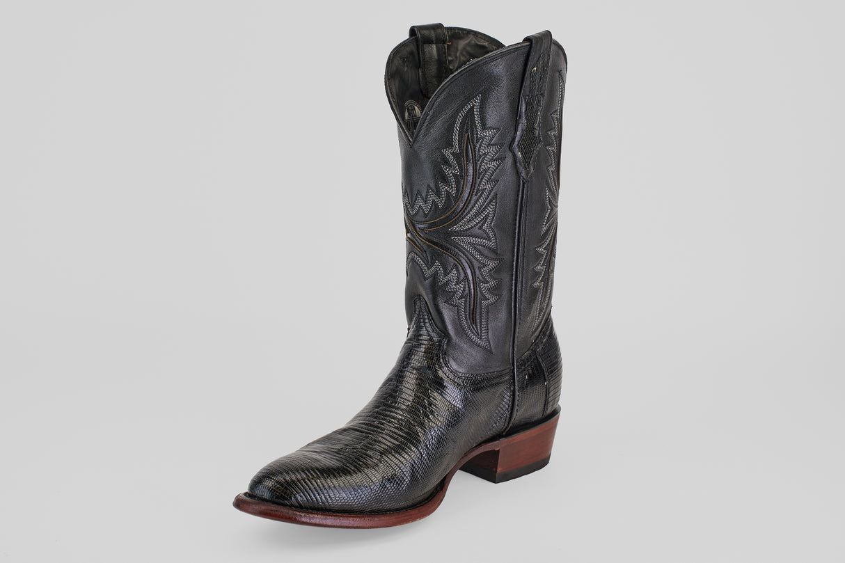 The Blaze – Black – Round Toe boot, made from sleek lizard leather with detailed stitching and a low wooden heel, is showcased on a plain light gray background.