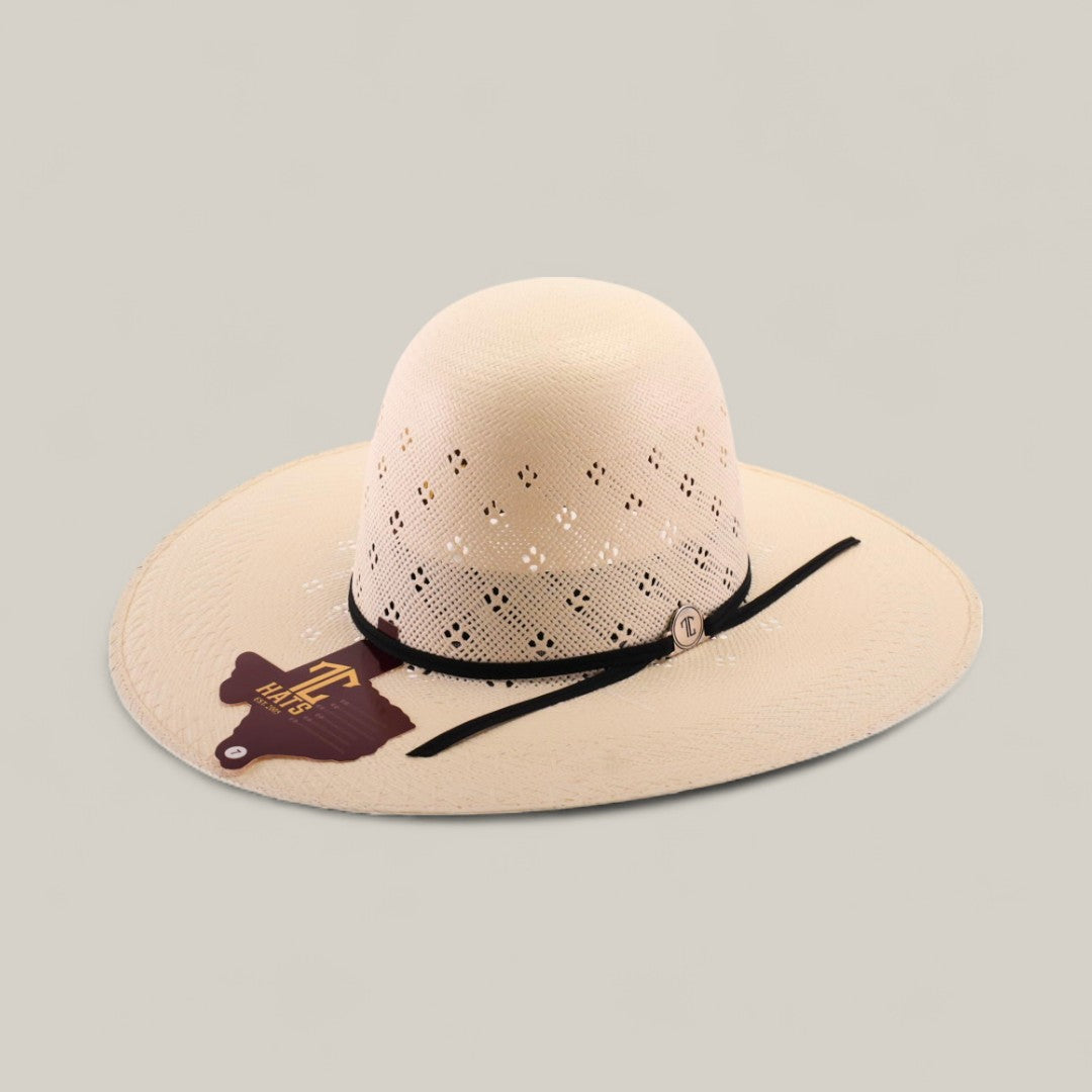 The 30X Clover - Open Crown is a wide-brimmed, light tan straw hat featuring decorative cut-out patterns, a black hatband, and a brown Texas-shaped tag on the brim. It’s shown against a plain light background.