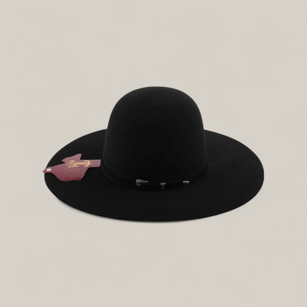 The 10X - Black - TC Hats features a wide brim, rounded crown, elegant decorative band, and a pink tag on the brim, shown against a plain beige background.