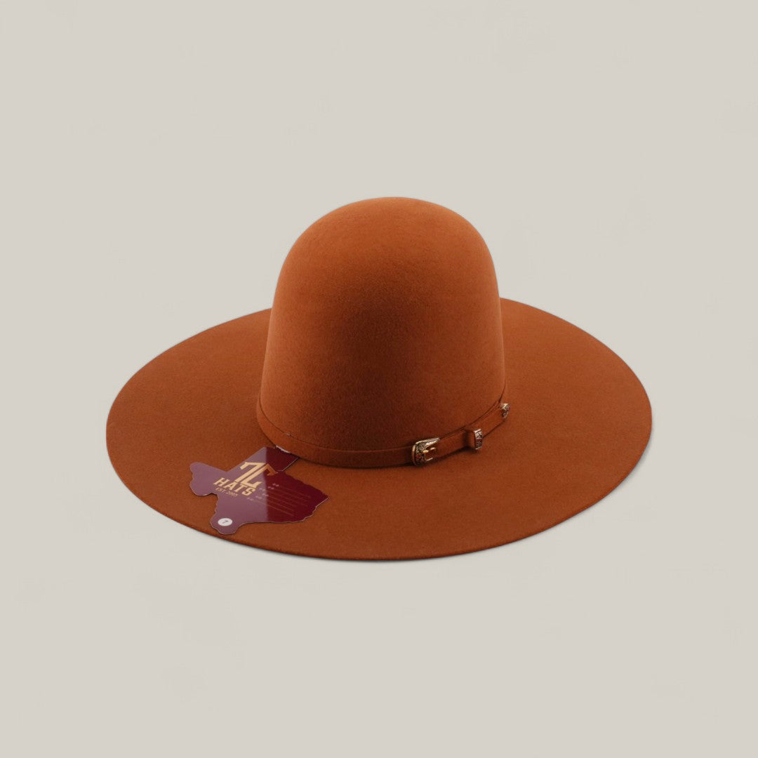 The 4x - Brick - TC Hats is a wide-brimmed, open crown Texana in burnt orange, featuring a decorative band and tag, shown against a plain light background.