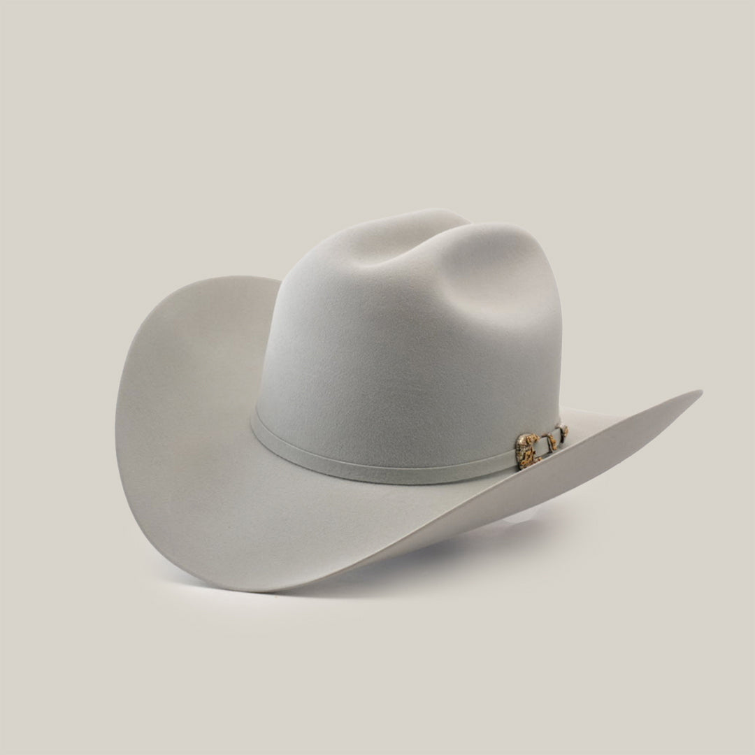 The 1000X Imperial Platinum is a light gray Larry Mahan cowboy hat with a wide brim, distinct crown crease, and decorative band with metal ornament, angled slightly on a plain backdrop, capturing the iconic western style.