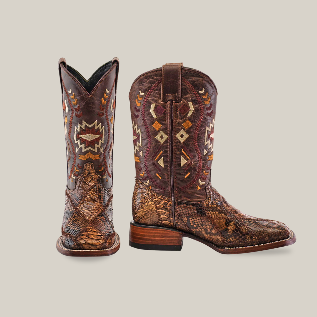 Two brown cowboy boots with intricate patterns and textured leather. One boot faces forward, and the other is viewed from the side, showcasing detailed stitching and design.