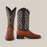 The Grisly Tan - Square Toe boots stand out in premium rich brown leather with intricate black and tan embroidery, featuring an ornate decorative design that highlights their Western-style cowboy boot appeal against a plain background.