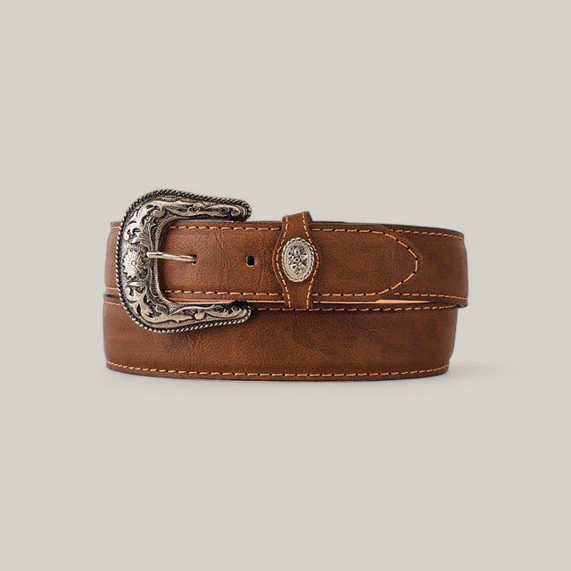 The Tan Plain Belt - Rustic Buckle is a tan leather belt with intricate floral patterns on the buckle, neatly coiled with visible stitching along the edges, set against a plain gray background.
