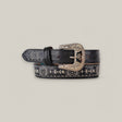 The Desert Black Belt - Texas Buckle embodies timeless elegance with its ornate silver buckle featuring intricate engravings. Decorative stitching enhances the Western-inspired design of this stylish womens belt.