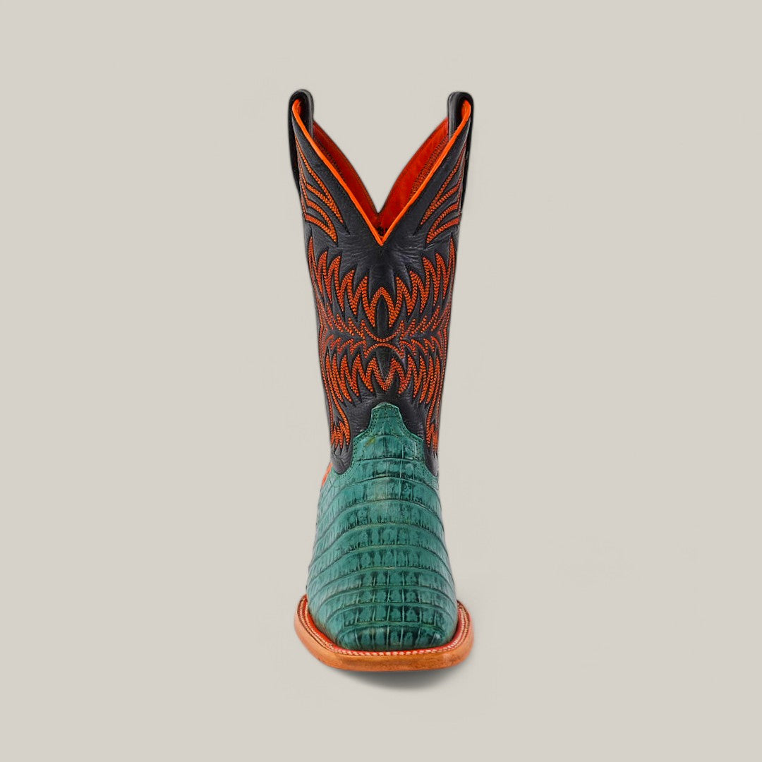 The front view of the Exotic Caiman Belly Tail - Green - Square Toe boots showcases a green, alligator-like textured lower section, paired with an orange and black upper featuring intricate stitching and a tan sole, against a plain background.