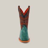 The front view of the Exotic Caiman Belly Tail - Green - Square Toe boots showcases a green, alligator-like textured lower section, paired with an orange and black upper featuring intricate stitching and a tan sole, against a plain background.