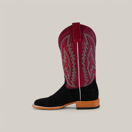 The Black Suede - Platinum - Square Toe boot showcases a western flair with its sleek black suede foot and burgundy shaft, highlighted by intricate white and red stitching. Platinum accents on the wooden heel and pull strap add elegance, set against a plain beige background for striking contrast.