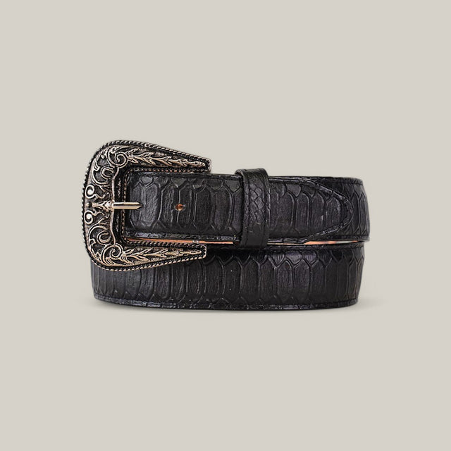 The Python Print Black Belt - Texas Buckle showcases a textured, crocodile-like pattern in black leather, paired with an ornate silver buckle featuring intricate engravings, all set against a plain beige background.