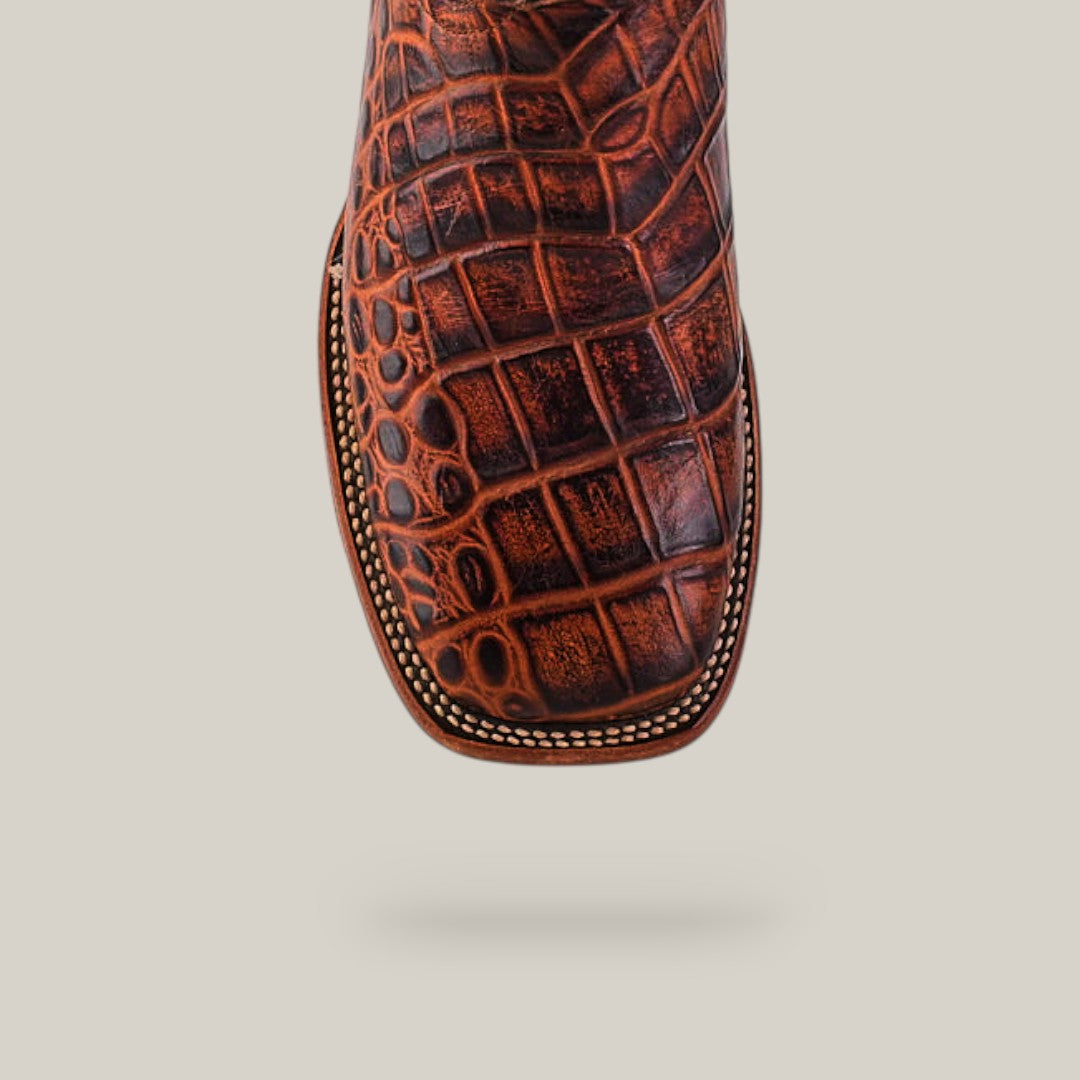 Top view of the Jonh - Cogñac - Square Toe boot, featuring cowhide leather with a crocodile pattern and decorative edge stitching, from the Last Call collection, shown isolated on a light background.