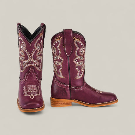 The Blake Purple - Square Toe - Kids Boots are shown from the front and side, featuring maroon color with white and silver embroidery, wooden soles, decorative stitching on the shaft and toe, plus a stylish and comfortable design.