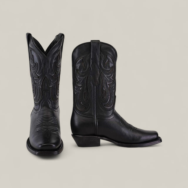 The Josie Full Black Short Shaft Narrow Square Toe womens cowboy boots, made of chic black leather with decorative stitching, are displayed against a plain light background—one boot facing forward, the other seen from the side.