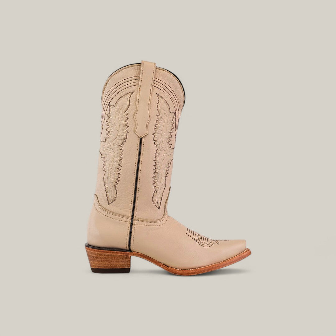 The Tessa Champagne - Mid Shaft - Snip Toe womens boot is shown on a plain off-white background, featuring decorative stitching, a pointed snip toe, and a wooden stacked heel.