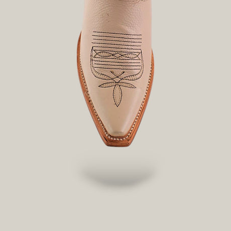 A close-up of the pointed toe of Tessa Champagne Mid Shaft snip toe boots, featuring beige color with brown embroidered patterns and a brown sole, set against a plain off-white background.