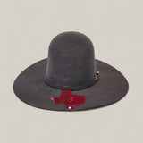 The 4X Gray - TC Hat is a wide-brimmed, dark gray open crown Texana Western hat featuring a gold buckle, decorative band, and a Texas-shaped A&M tag representing Texas A&M University, displayed on a light background.