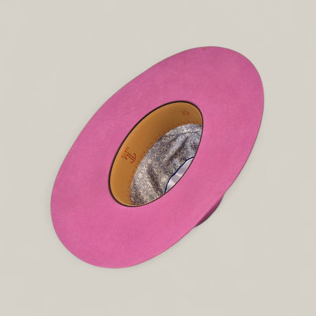 The 4x Pink - TC Hats is a wide-brimmed, bright pink Open Crown Texana Western hat displayed upside down, showcasing its tan patterned interior lining and decorative band against a plain light background.
