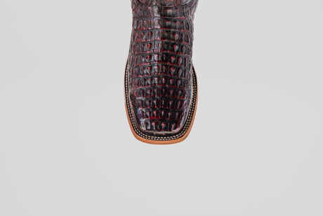 A close-up of the Exotic Caiman Horn Back - Black Cherry - Square Toe boot shows its dark crocodile pattern, square tip, and detailed stitching on the tan sole against a plain light background.
