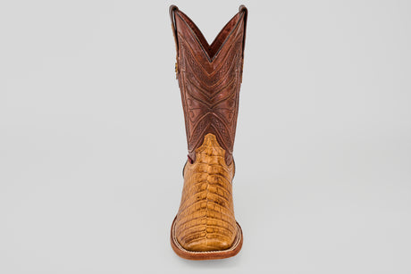 Front view of the Exotic Caiman Belly - Camel - Square Toe boot, featuring a light brown caiman leather lower and a darker brown, stitched upper shaft, displayed against a plain gray background.