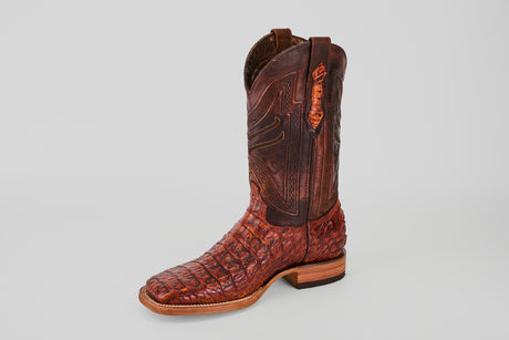 The Exotic Caiman Horn Back - Smoke Cogñac - Square Toe boot, featuring intricate stitching and textured caiman leather, stands upright on a plain gray background, highlighting its premium elegance.