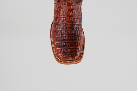 Close-up of the toe of the Exotic Caiman Horn Back - Smoke Cogñac- Square Toe boot, featuring brown, crocodile-patterned caiman leather and decorative edge stitching, set against a light gray background.