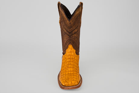 The Exotic Caiman Horn Back - Buttercup-Square Toe is shown from the front, featuring a textured bright yellow caiman leather foot and a brown, intricately stitched shaft against a plain gray background.