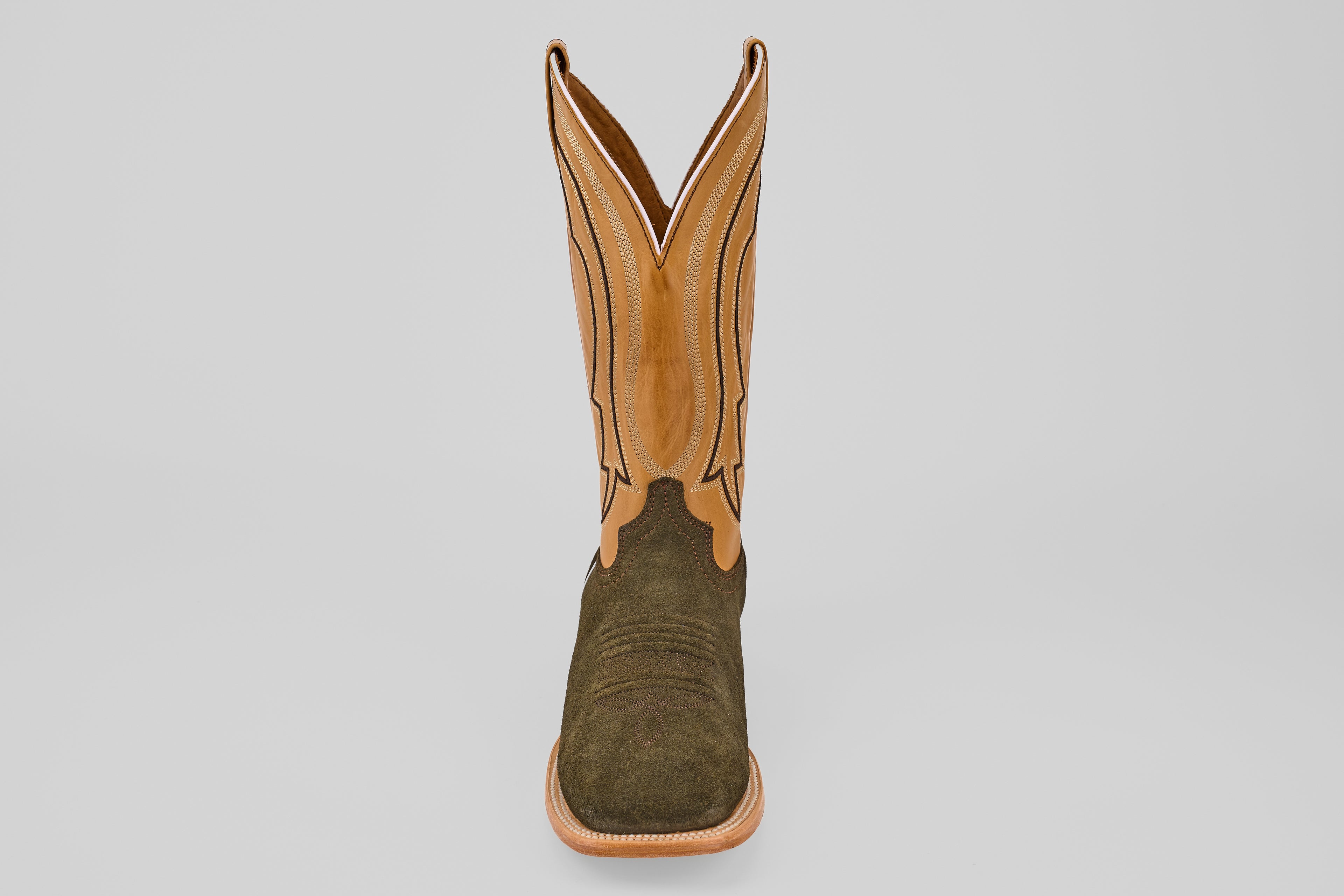 The Prime Suede Green Olive - Square Toe men’s boot features a green olive suede foot, tan leather shaft with decorative stitching, and a square toe, displayed facing forward on a plain light background.