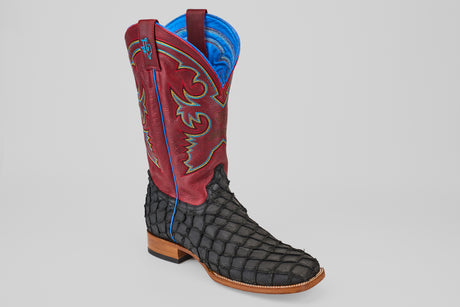 The Dodge - Matte Black - Square Toe is a mens luxury boot with a black textured Pirarucu leather foot, brown sole, tall red leather upper with blue and yellow stitching, and blue lining—crafted for standout Western style.