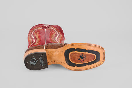 The Thompson - Red / Brown - Square Toe boot rests on its side, showcasing intricate stitching on the upper and sole, along with brand logos and decorative patterns, all set against a light gray background.