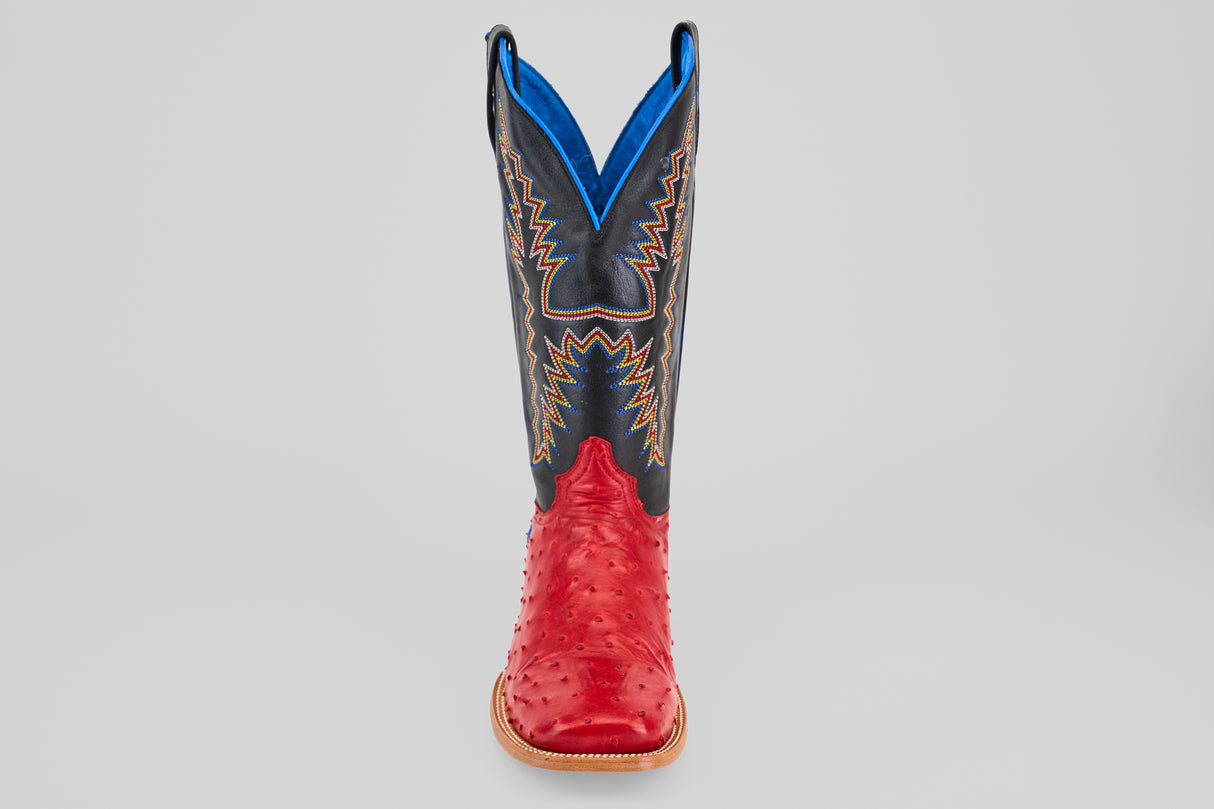 The Crowley - Red - Square Toe boot features a red leather foot, a black and blue shaft with yellow and blue stitching, and is displayed upright against a gray background.