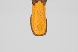 The Exotic Full Quilt Ostrich - Buttercup- Square Toe cowboy boot, handcrafted from yellow ostrich leather with a square toe, is shown from above on a light gray background.