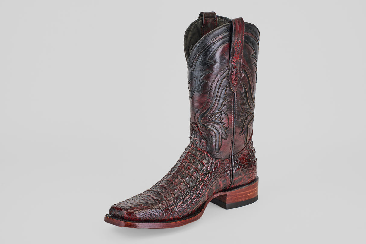 The Exotic Caiman Hornback - Blackcherry - Rodeo Toe cowboy boot, featuring intricate texture, decorative stitching, and a wooden heel, is displayed against a plain white background.