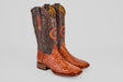 The Austin - Brandy - Square Toe boots feature brown leather uppers with decorative stitching and orange Avestruz Brandy ostrich leather lowers, displayed on a plain light gray background.