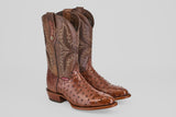The Austin - Brown - Round Toe cowboy boots feature decorative shaft stitching and a textured, glossy avestruz finish on the foot, shown against a simple light background.