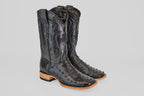 The Austin - Black - Square Toe boots feature decorative stitching, square toes, and light brown stacked heels, crafted in black avestruz leather and displayed against a plain light gray background.