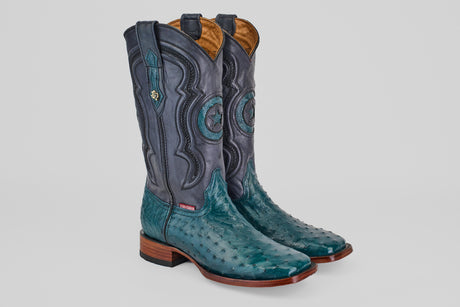 A pair of Austin - Gasoline Green - Square Toe ostrich leather cowboy boots with turquoise feet, dark blue shafts, decorative stitching, and wooden heels sits on a plain white background.