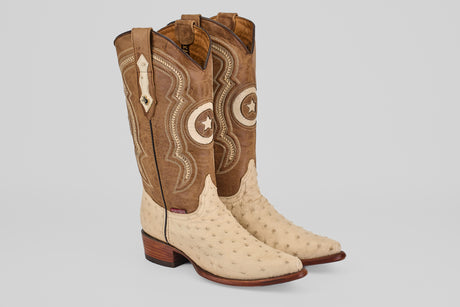 The Austin - Bone - Snip Toe cowboy boots feature a light bone ostrich leather foot, brown stitched shafts with star designs, snip toes, pull straps, and stylish wooden heels.
