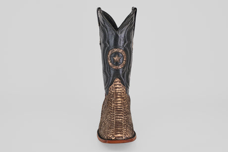 The Tanner - Rustic Bone - Square Toe cowboy boot features a brown snakeskin-textured lower, black upper shaft, and a decorative star emblem on the front—reflecting Western craftsmanship and the allure of exotic leather.