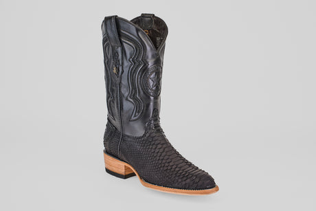 The Tanner – Matte Black – Roper Toe boot features scaly textured detail on the foot, decorative shaft stitching, and a light brown wooden heel, shown individually against a plain white background.