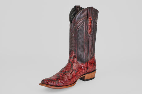 The Tanner – Ruby – Narrow Square Toe is a single western boot in red and brown snakeskin leather with decorative stitching, a pointed toe, and a low wooden heel, shown on a plain light background.