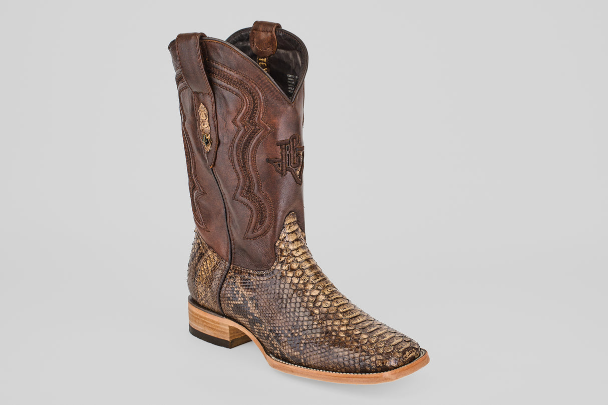 The Tanner – Dune – Square Toe boot features a brown leather upper, textured snakeskin-patterned lower section, decorative stitching, and a light wooden heel, displayed against a plain gray background.