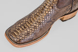 Close-up of the Tanner – Dune – Square Toe boot, crafted from brown python leather with detailed stitching, highlighting its western-inspired design against a light gray background.