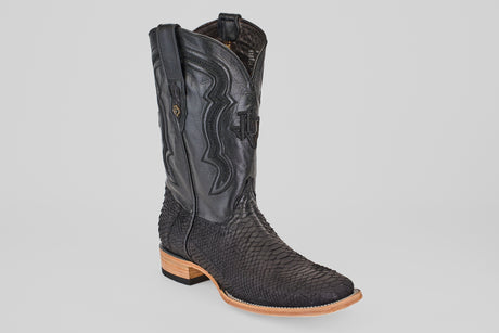 The Tanner - Matte Black - Square Toe cowboy boot features Python Negro textured leather, a smooth upper with decorative stitching, and a light brown wooden heel and sole (Model PN30), set against a plain light background.