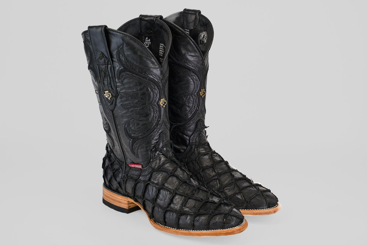 The Conor - Matte Black - Roper Toe boots feature textured pirarucu fish leather, high-calf design, decorative stitching, and light brown wooden heels, all showcased against a plain gray background.