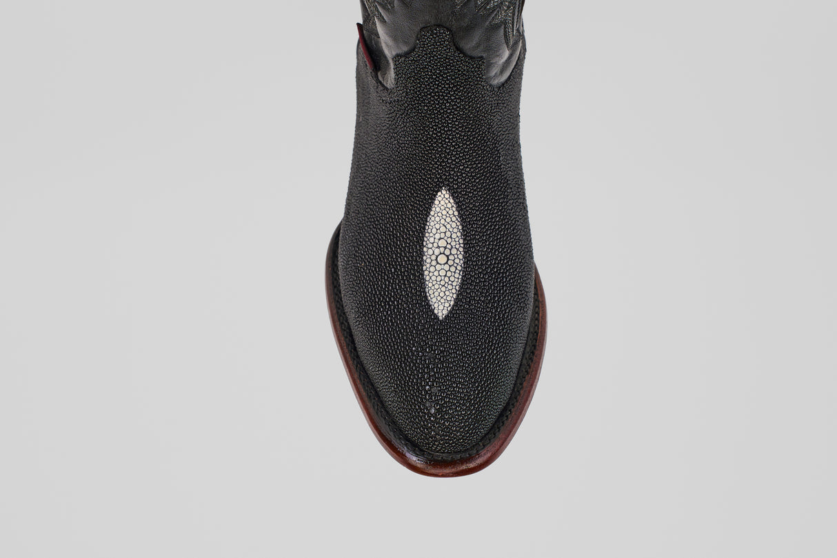 A close-up, top-down view of the Ranger – Black – Round Toe boot, featuring stingray leather with a white oval inlay on the toe and a brown sole, set against a light gray background—perfect for stylish men’s cowboy boot seekers.